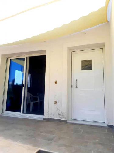 Πόρτα συρόμενη επάλληλη με σήτα και τζάμια ενεργειακά 4 εποχών, σειράς Europa 100 και πόρτα ανοιγόμενη κυρίας εισόδου με πάνελ αλουμινίου, σειράς Europa 850